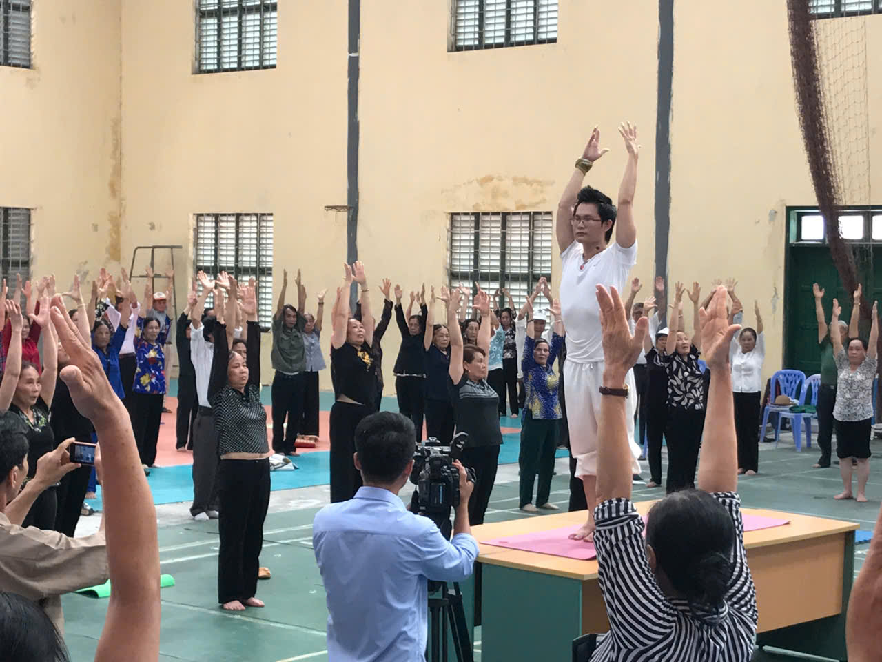 Vì Sao Uỷ Ban Olympic Việt Nam Trao Bằng Khen Cho Một Giám Đốc Học Viện Yoga? 8 Giám đốc Học viện Yoga T.Kim Việt Nam đứng trên bàn dạy tư thế Chào Mặt Trời cho hơn 200 hội viên cao tuổi tại Sở Thể Thao Hưng Yên