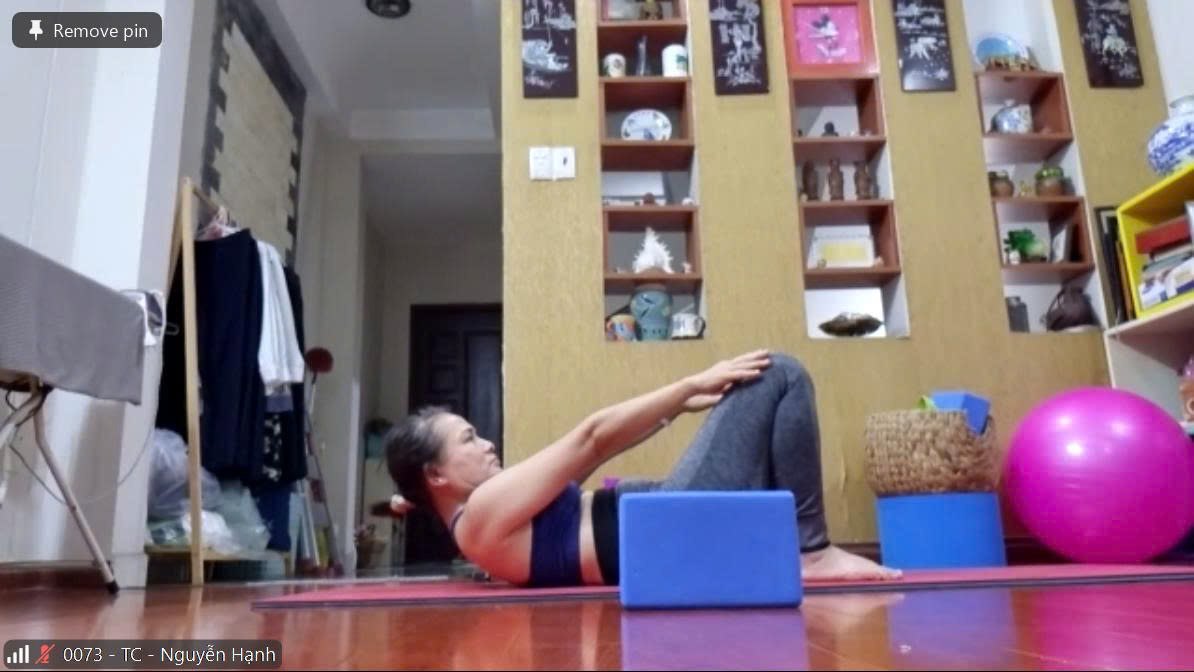 Hành Trình 4 Năm Bền Bỉ Cùng Lớp Yoga Online T.Kim — Đau Lưng & Tê 4 Chi Cải Thiện Rõ Rệt Mỗi Ngày 8 Chị Nguyễn Hạnh tập bài cơ bụng với gối hỗ trợ trong buổi học Yoga Online qua Zoom tại Học viện Yoga T.Kim Việt Nam, thực hành ngay tại nhà