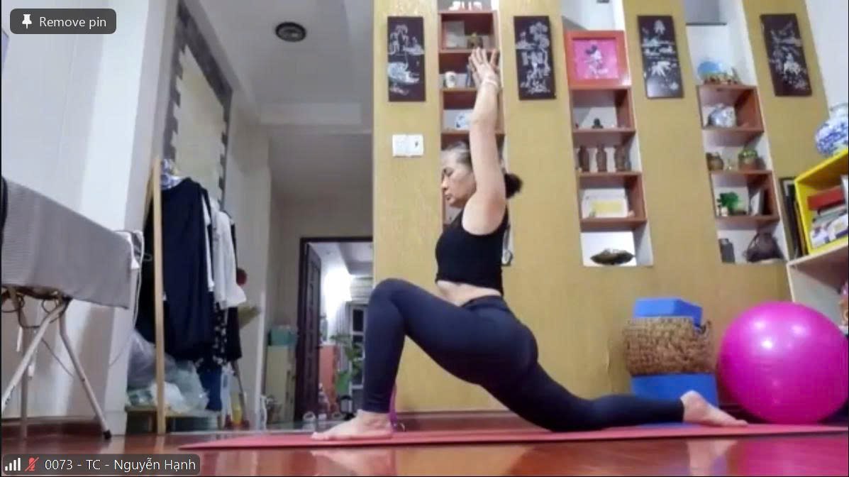 Hành Trình 4 Năm Bền Bỉ Cùng Lớp Yoga Online T.Kim — Đau Lưng & Tê 4 Chi Cải Thiện Rõ Rệt Mỗi Ngày 7 Chị Nguyễn Hạnh tập tư thế Chiến binh thấp trong buổi học Yoga Online qua Zoom tại Học viện Yoga T.Kim Việt Nam, ngay tại nhà với thảm cam và bóng yoga hồng