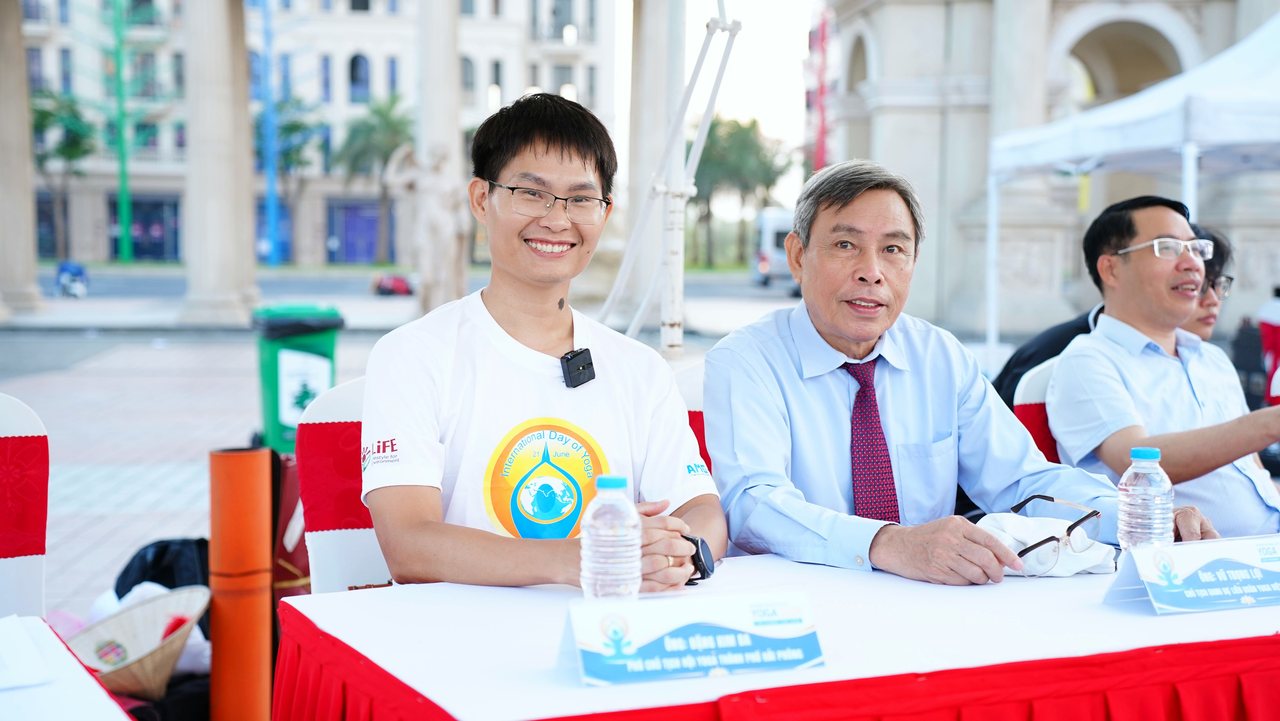 Tổng đạo diễn ở bàn cuối: người dựng cả buổi sáng Quốc tế Yoga Hải Phòng 2026 rồi lùi về sau ống kính 8 Đặng Kim Ba bên ông Vũ Trọng Lợi, Chủ tịch danh dự Liên đoàn Yoga Việt Nam