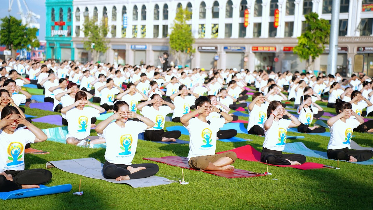 Tổng đạo diễn ở bàn cuối: người dựng cả buổi sáng Quốc tế Yoga Hải Phòng 2026 rồi lùi về sau ống kính 12 Đặng Kim Ba xuống sân trải thảm tập cùng học viên tại Quốc tế Yoga Hải Phòng 2026