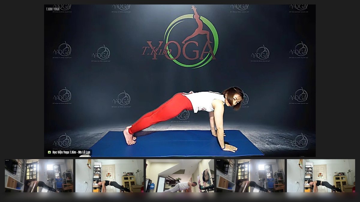 Huấn luyện viên Lê Lan làm mẫu tư thế plank nghiêng siết cơ lõi, học viên tập theo qua màn hình trong lớp Yoga Online T.Kim